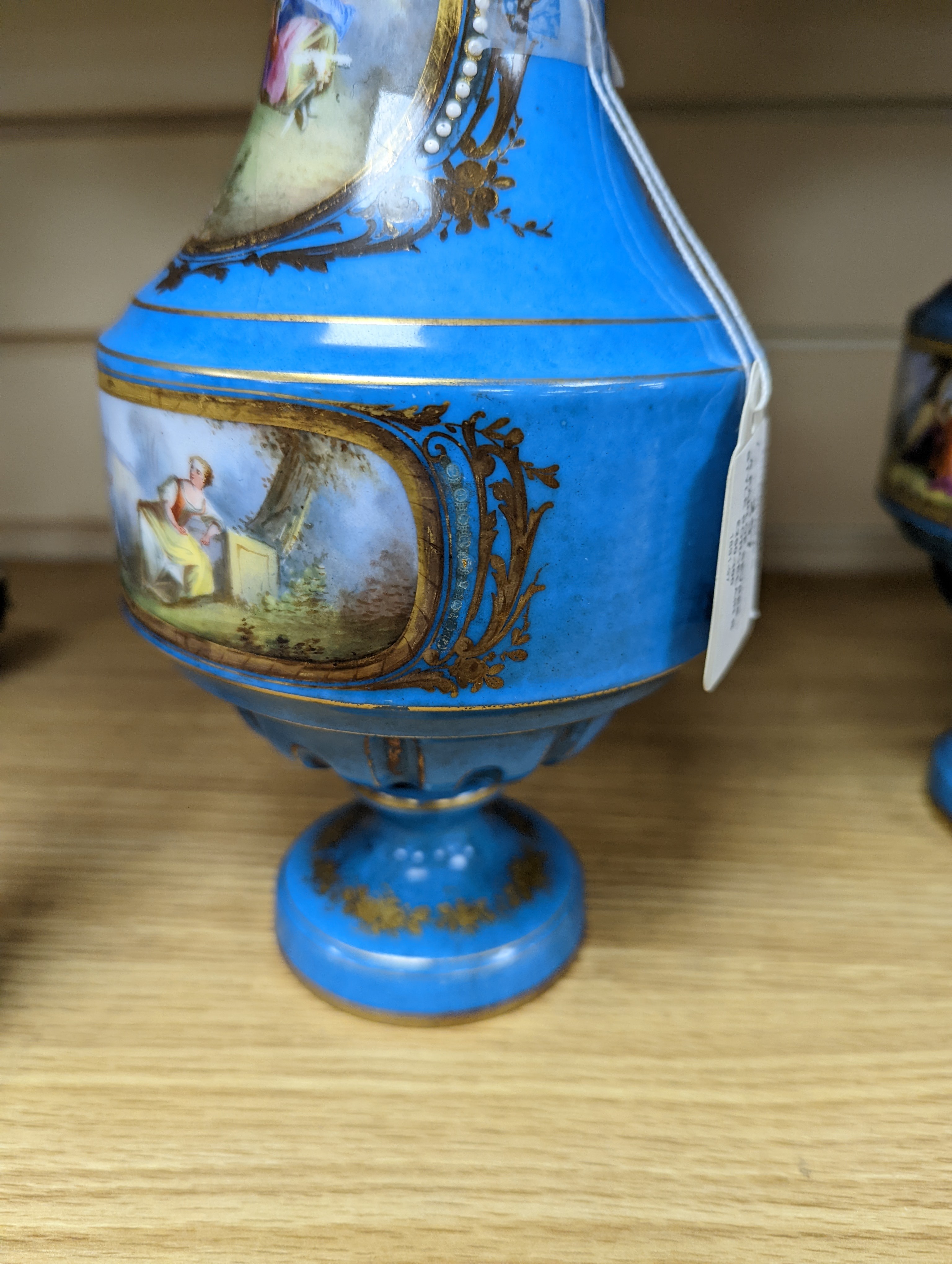 A pair of Sevres style porcelain bleu celeste ground vases and covers, 34cm